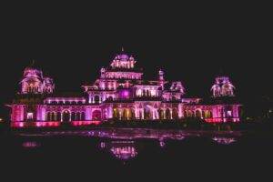 Dazzling illuminated night view of Albert Hall Museum in Jaipur, showcasing its architectural beauty and reflection.