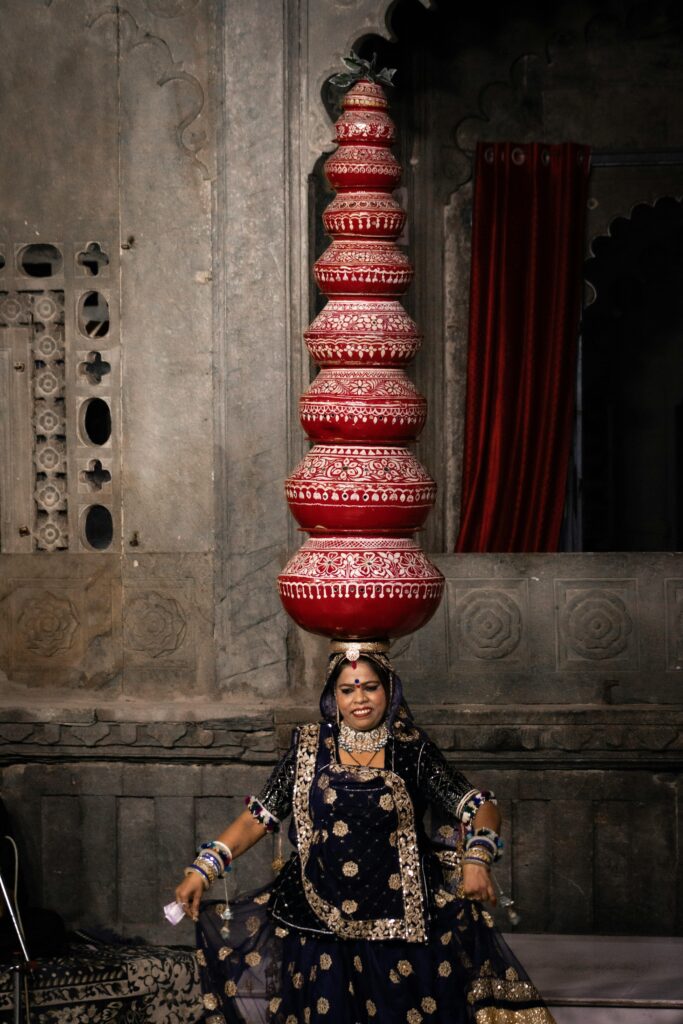 A woman performing a traditional Rajasthani folk dance in Udaipur, balancing pots.