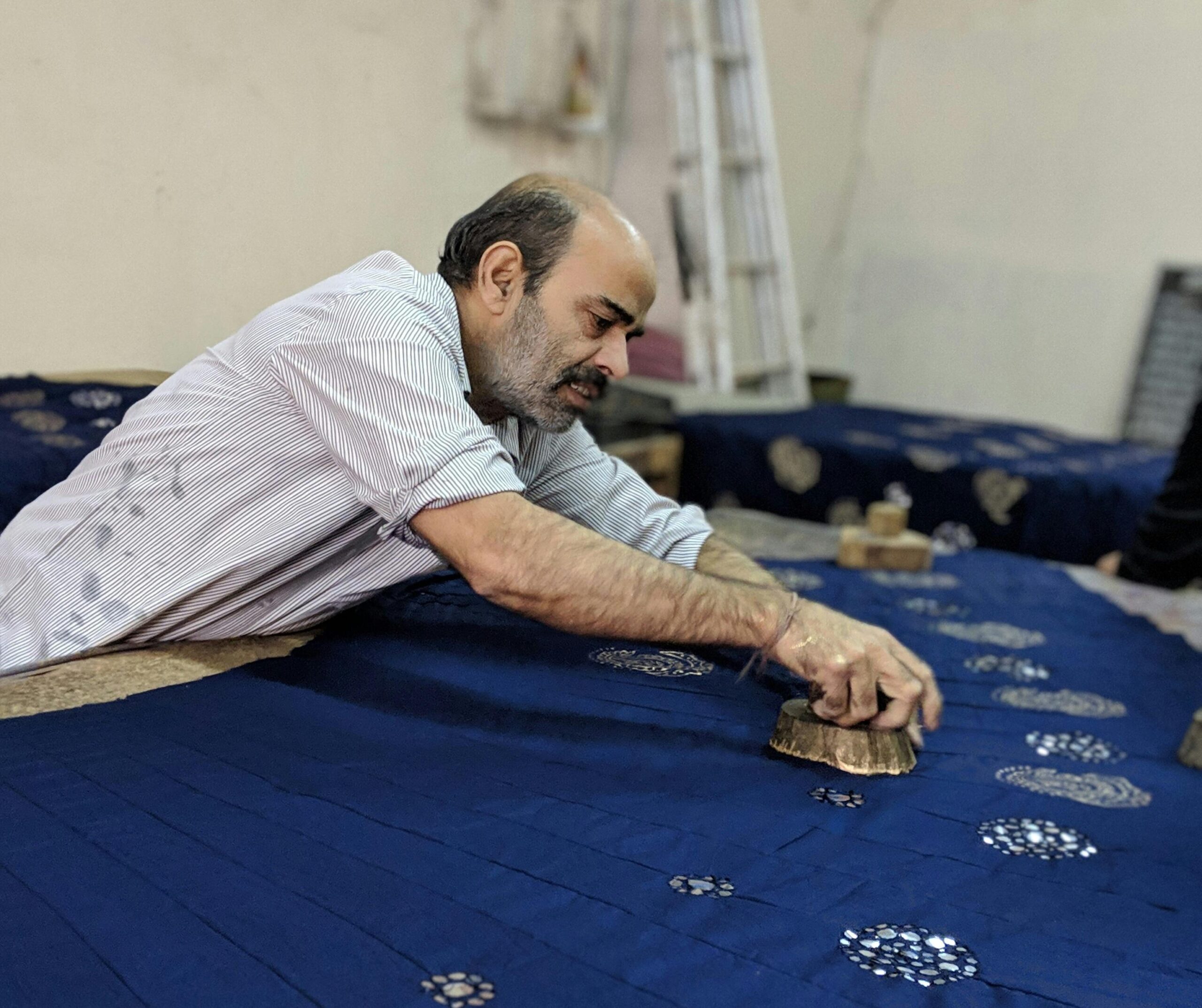 Traditional block printing on blue fabric, showcasing Rajasthan culture heritage
